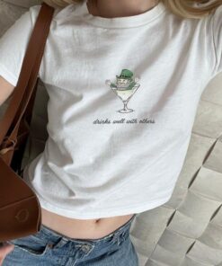 St. Patrick's Day Women’s Baby Tee - Leprechaun Martini Cocktail "Drinks Well with Others" Funny Tee